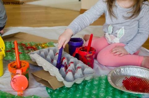 child painting egg carton