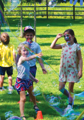 children with facepaint and giant bubbles