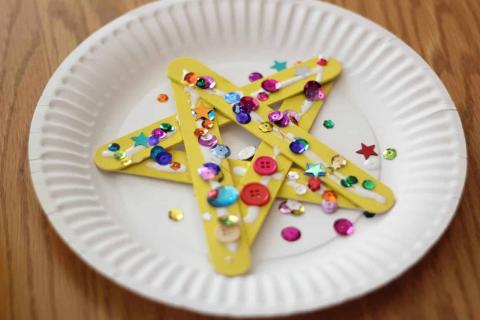 A paper plate with a star made of plastic and buttons