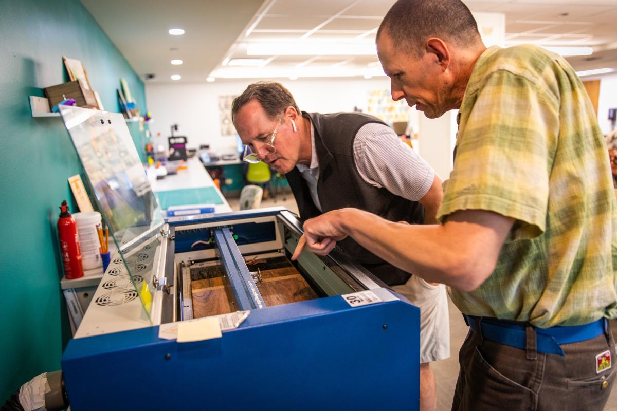 People working at laser engraver station