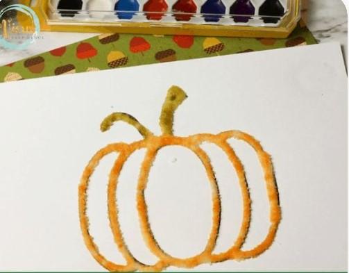 outline of a pumpkin with watercolor paints nearby