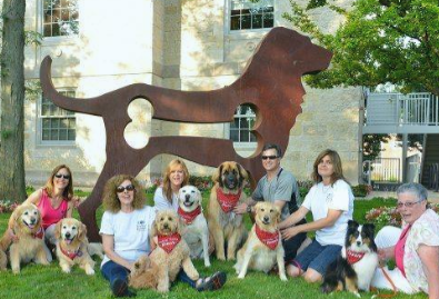 Various people sitting outside with wonderful dogs!